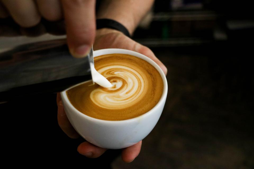 Picture of a barista pouring a perfect cappuccino.